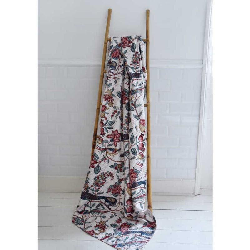 The Pemberely blankey elegantly drapped over a wooden ladder. Displaying the rich colours and the beautful design of the throw