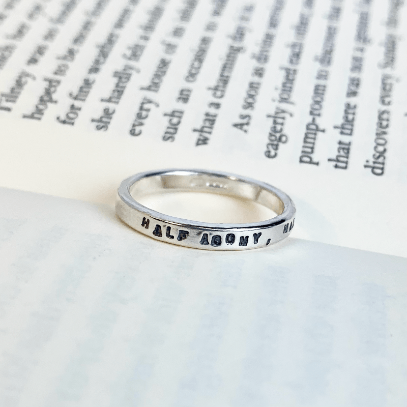 Half agony half hope quote ring displayed between book pages, to show it's connection with Jane Austen and literature 
